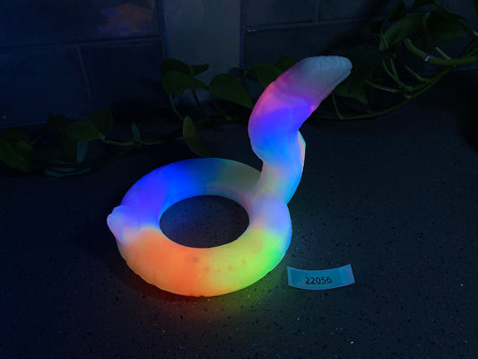 a glow ring sitting on a table next to a plant