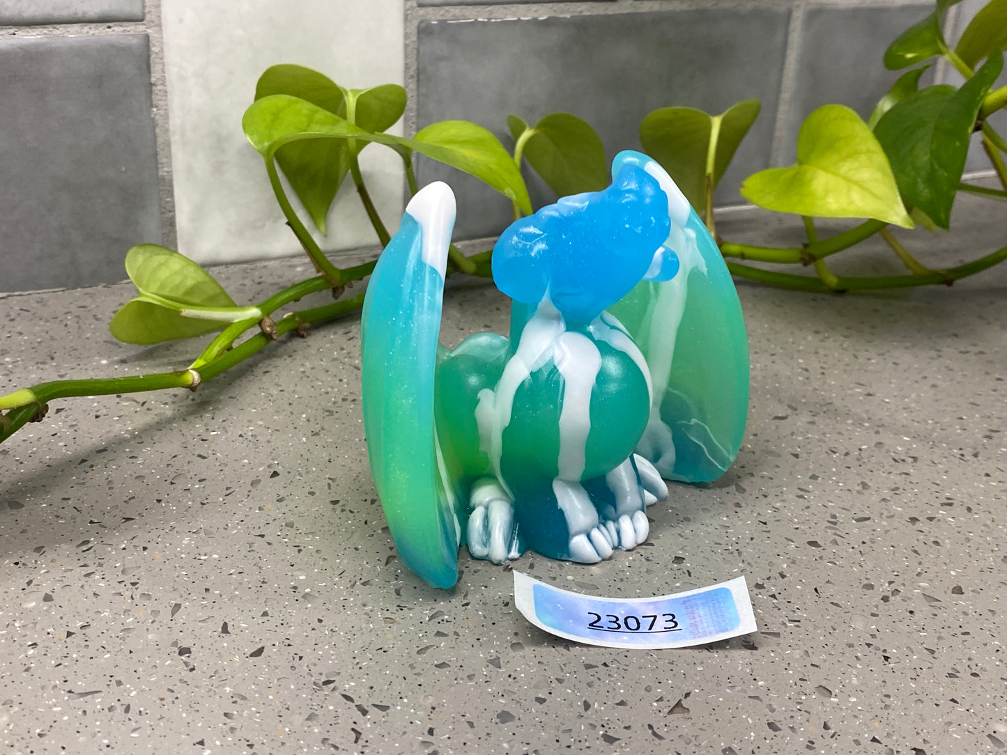 a glass figurine of a cat with a name tag