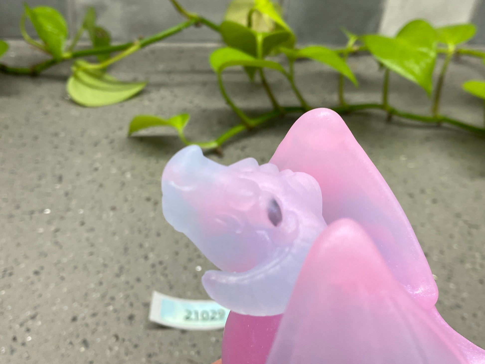 a plastic toy of a pink dragon on a table