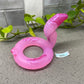 a pink toy sitting on top of a counter next to a plant