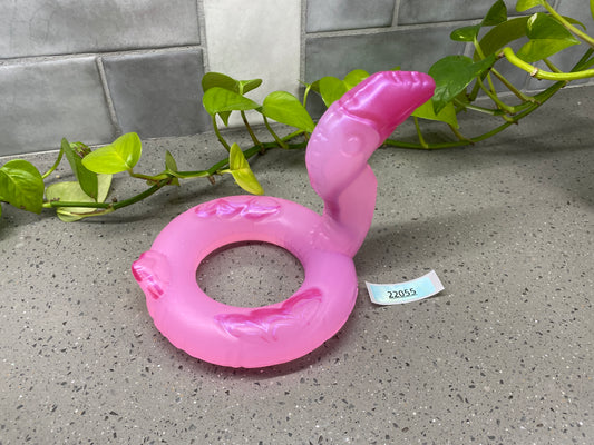 a pink toy sitting on top of a counter next to a plant