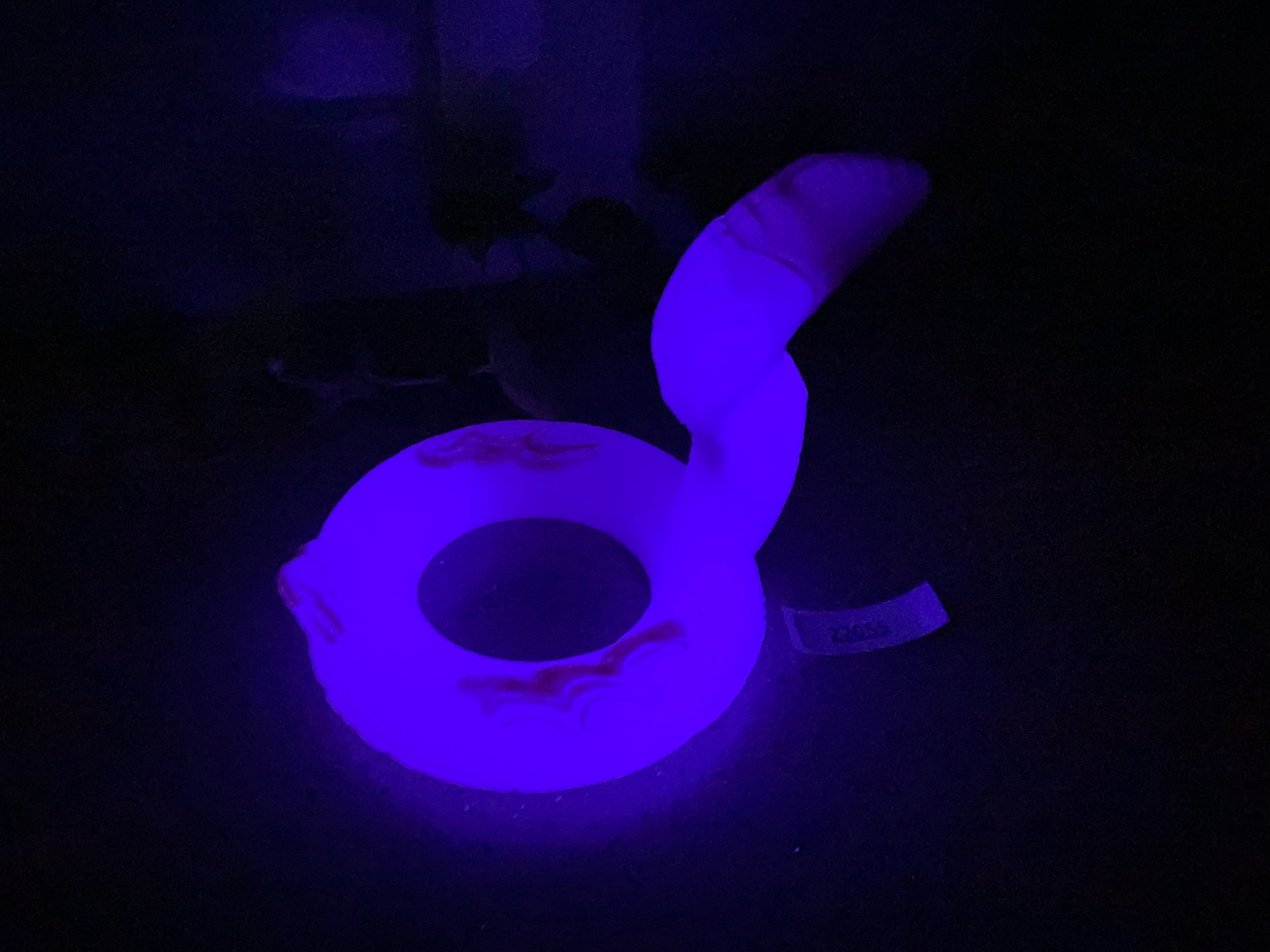 a dark room with a purple light on a toilet