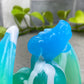 a close up of a blue and green toothbrush holder