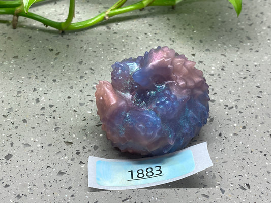 a purple and blue rock sitting on top of a table