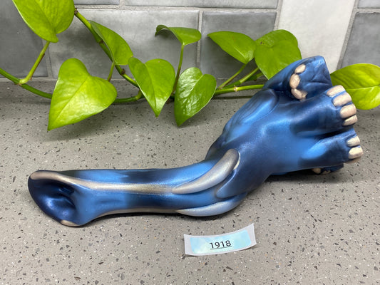 a blue statue of a foot with a stick sticking out of it
