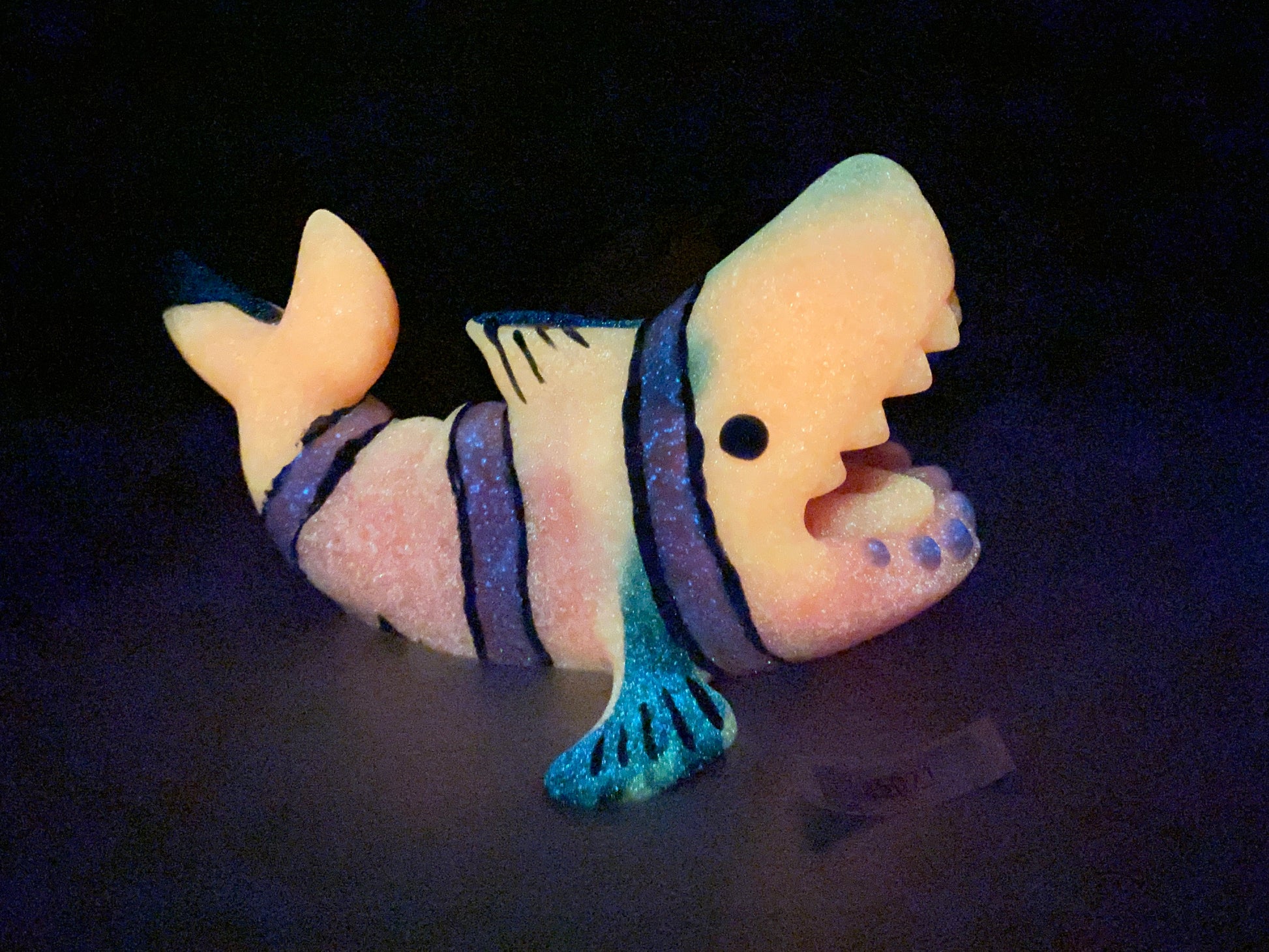 a small toy fish with a blue stripe around its body