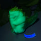 a glow in the dark figurine of a baby in a cucumber