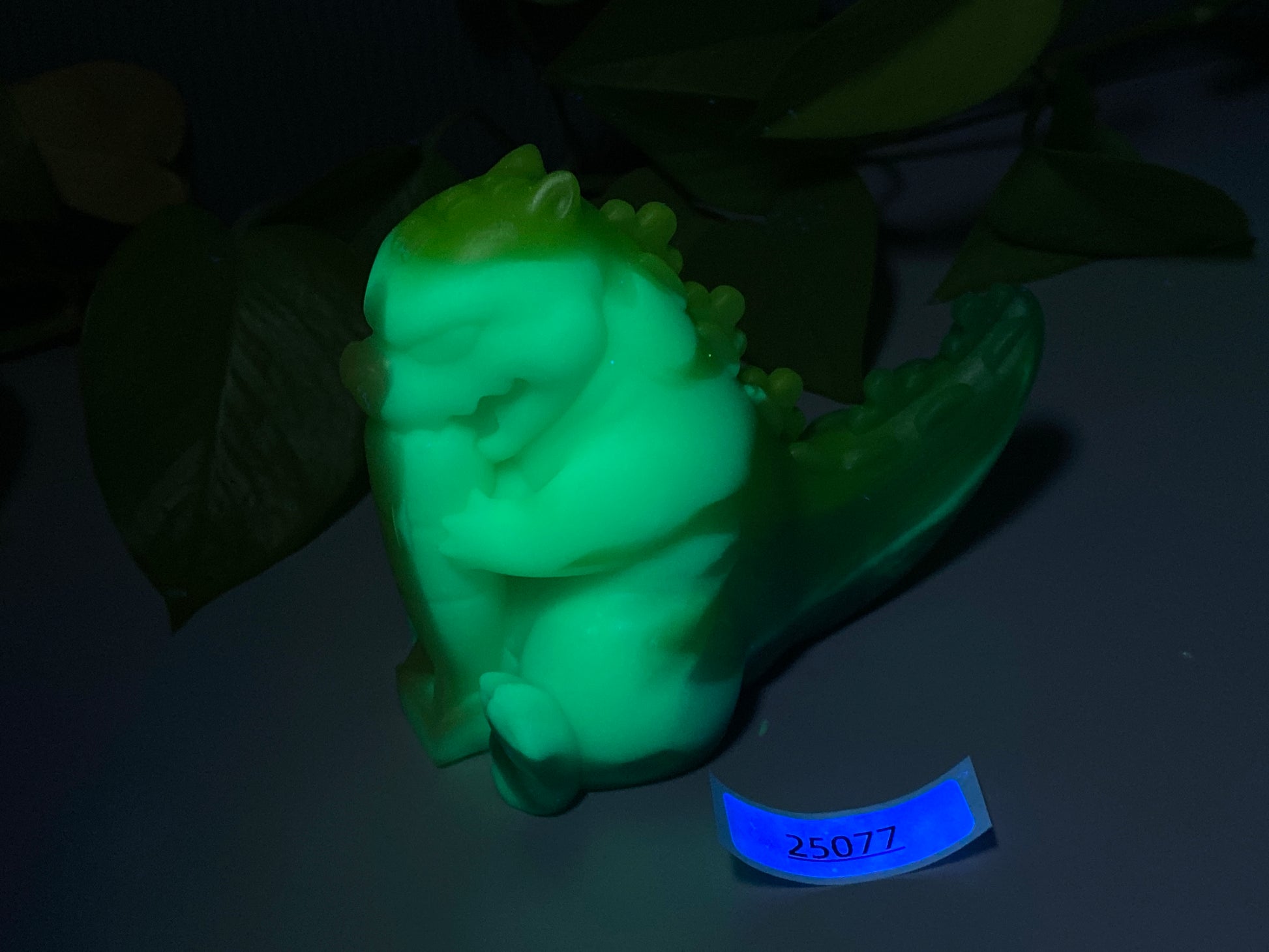 a glow in the dark figurine of a baby in a cucumber