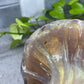 a glass vase sitting on top of a table next to a plant