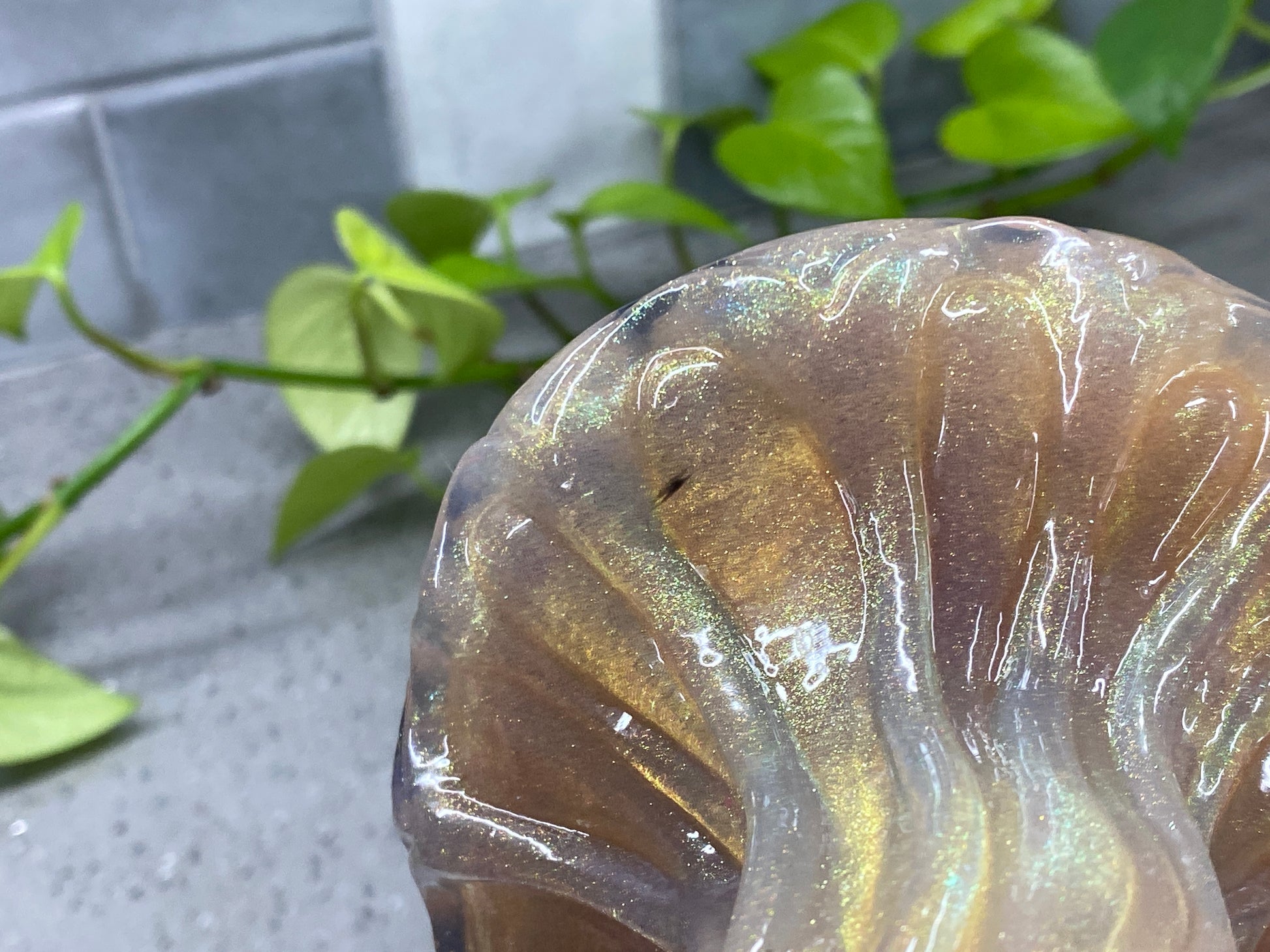 a glass vase sitting on top of a table next to a plant