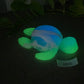 a glow in the dark turtle toy laying on the ground