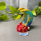 a colorful figurine sitting on top of a table next to a plant