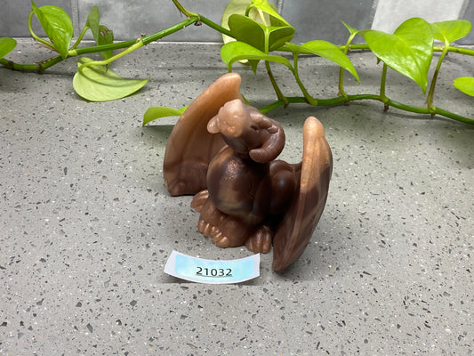 a figurine of a squirrel on the ground next to a plant