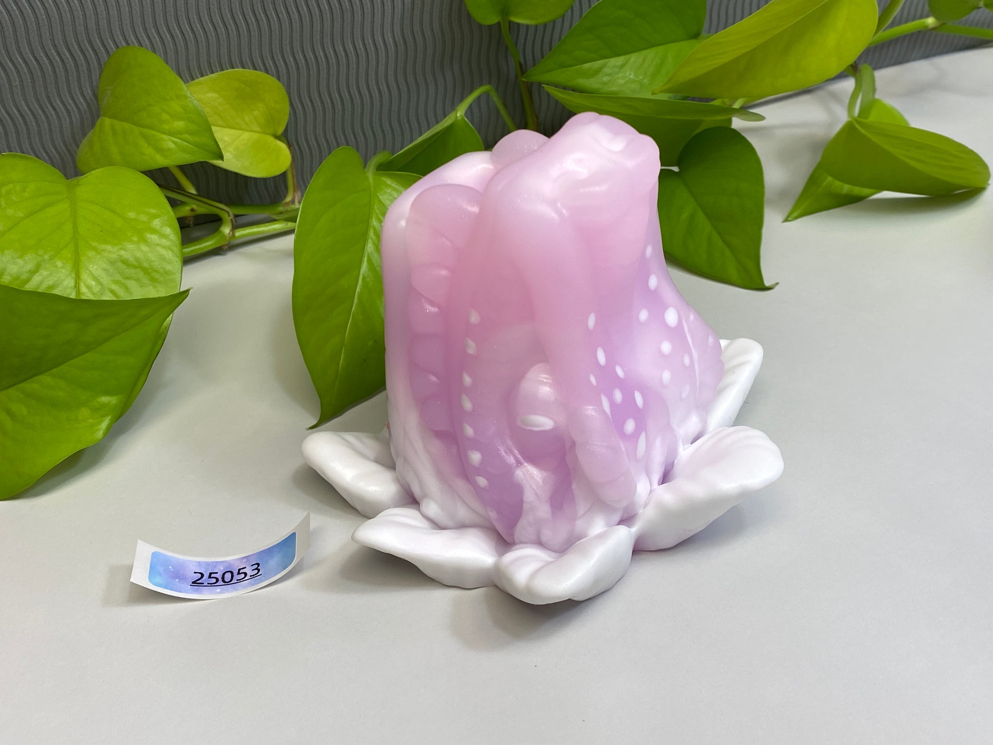 a pink flower sitting on top of a white table