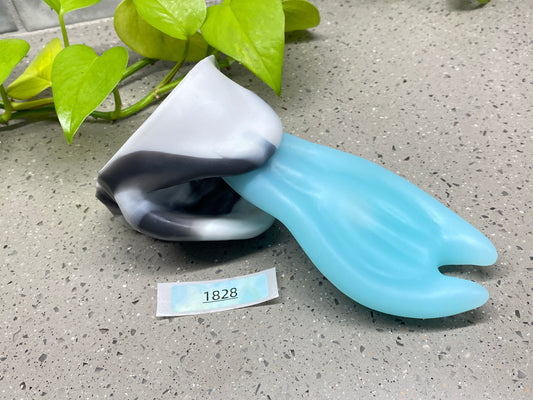 a blue and black object sitting next to a plant