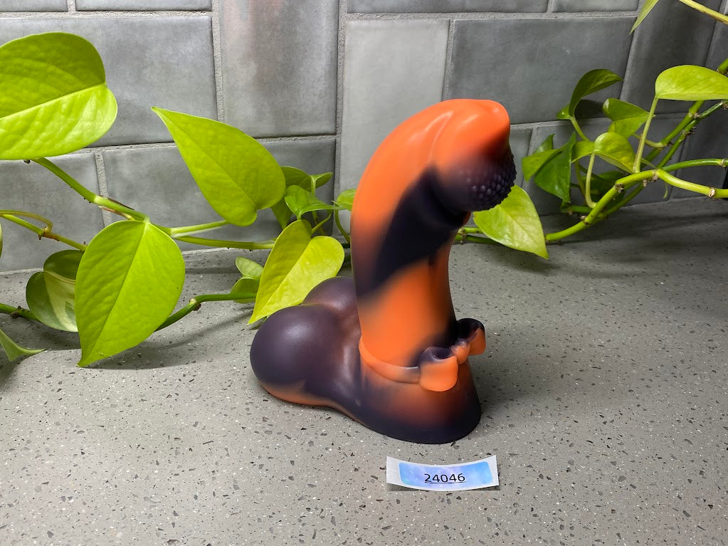 a rubber toy sitting on top of a table next to a plant