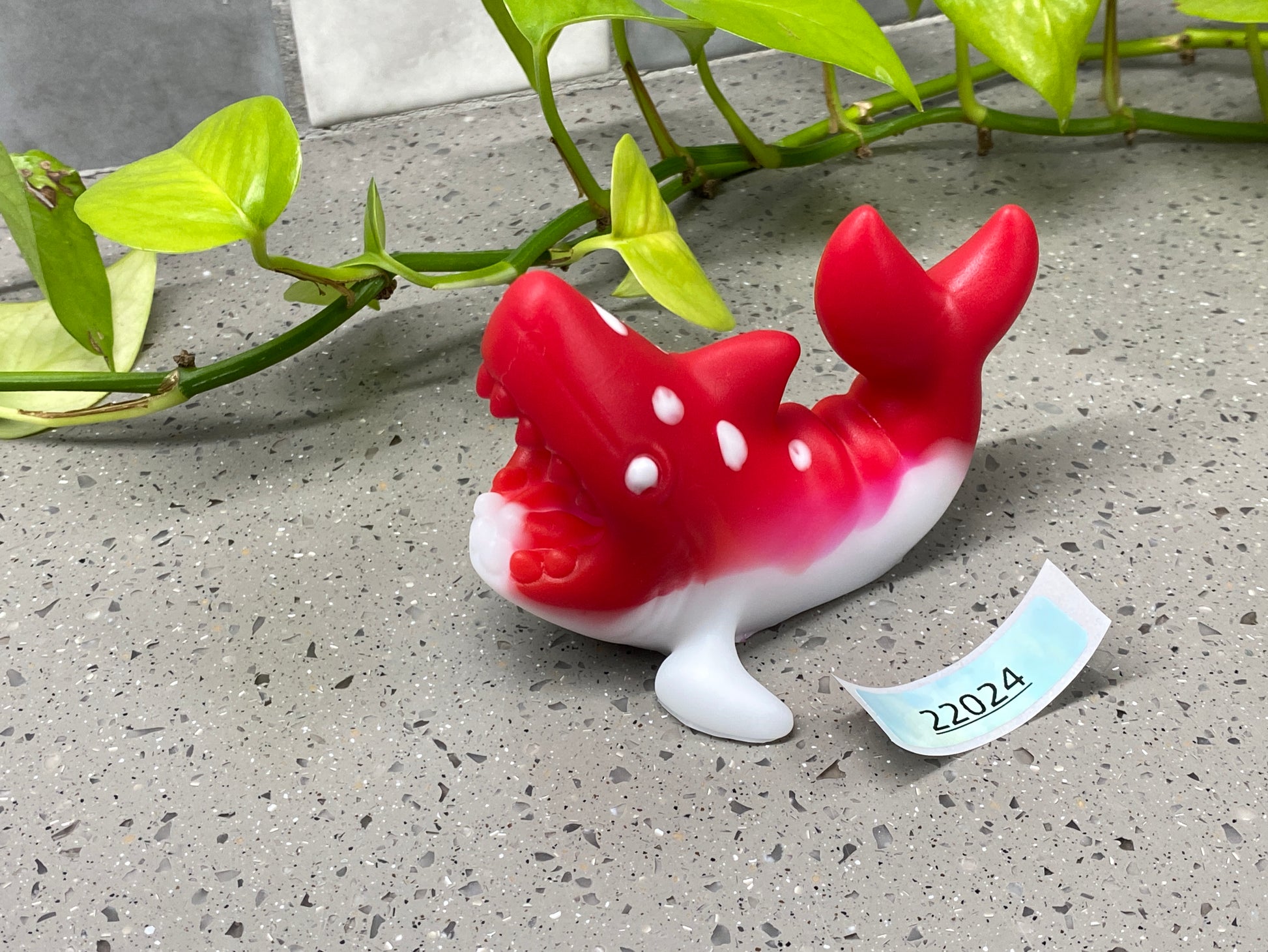 a red and white fish figurine sitting on top of a table