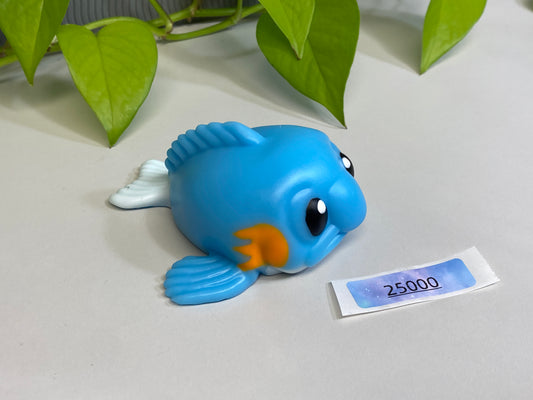 a blue toy fish sitting on top of a table