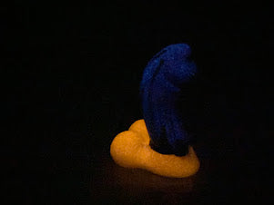 a blue banana sitting on top of an orange