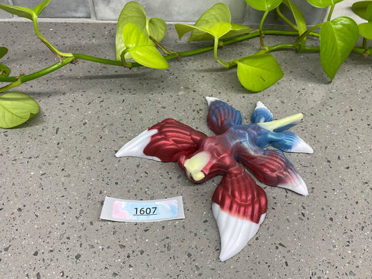 a ceramic bird on a table next to a plant