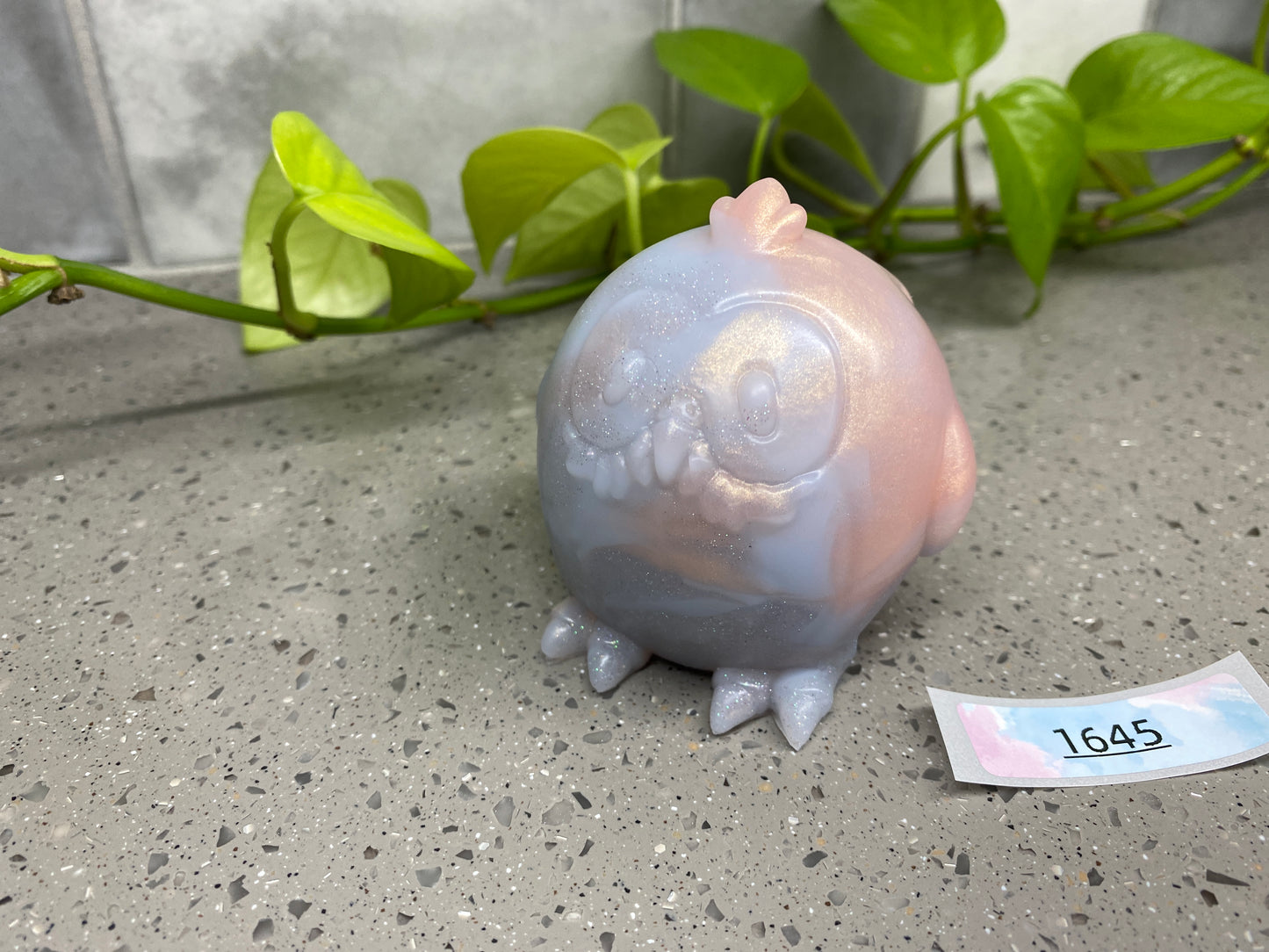 a glass owl figurine sitting next to a plant