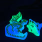 two glow in the dark objects on a black surface