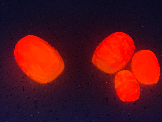a group of orange balls sitting on top of a black surface