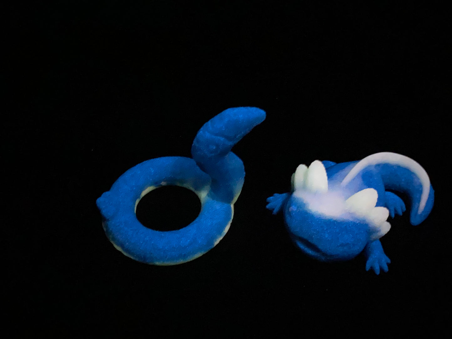 a blue and white toy laying on top of a black surface