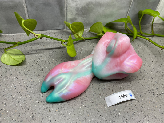 a pink and blue sculpture sitting on top of a cement floor
