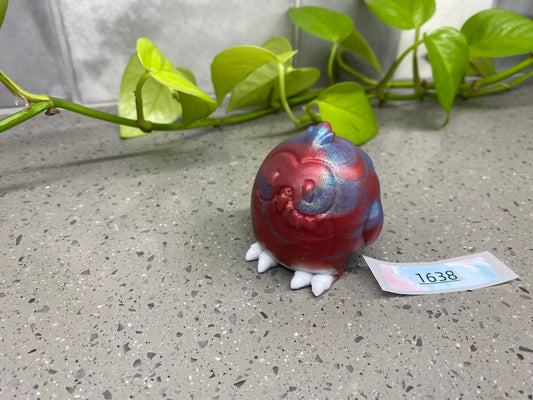 a red and blue bird figurine sitting on top of a table