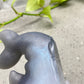 a close up of a metal object with a plant in the background