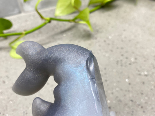 a close up of a metal object with a plant in the background