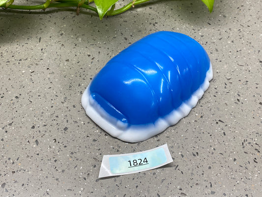 a blue object sitting on top of a table next to a plant