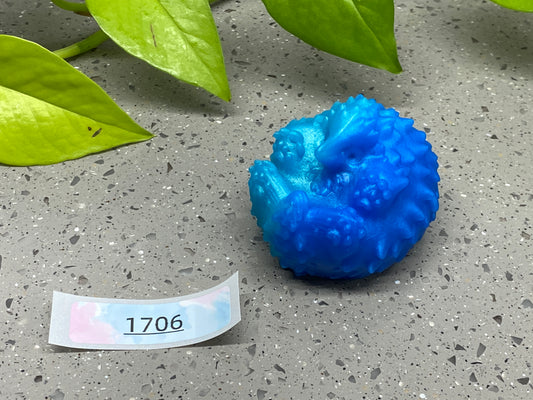 a blue ball sitting on top of a table next to a green plant