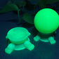 a green plastic turtle next to a green plastic ball