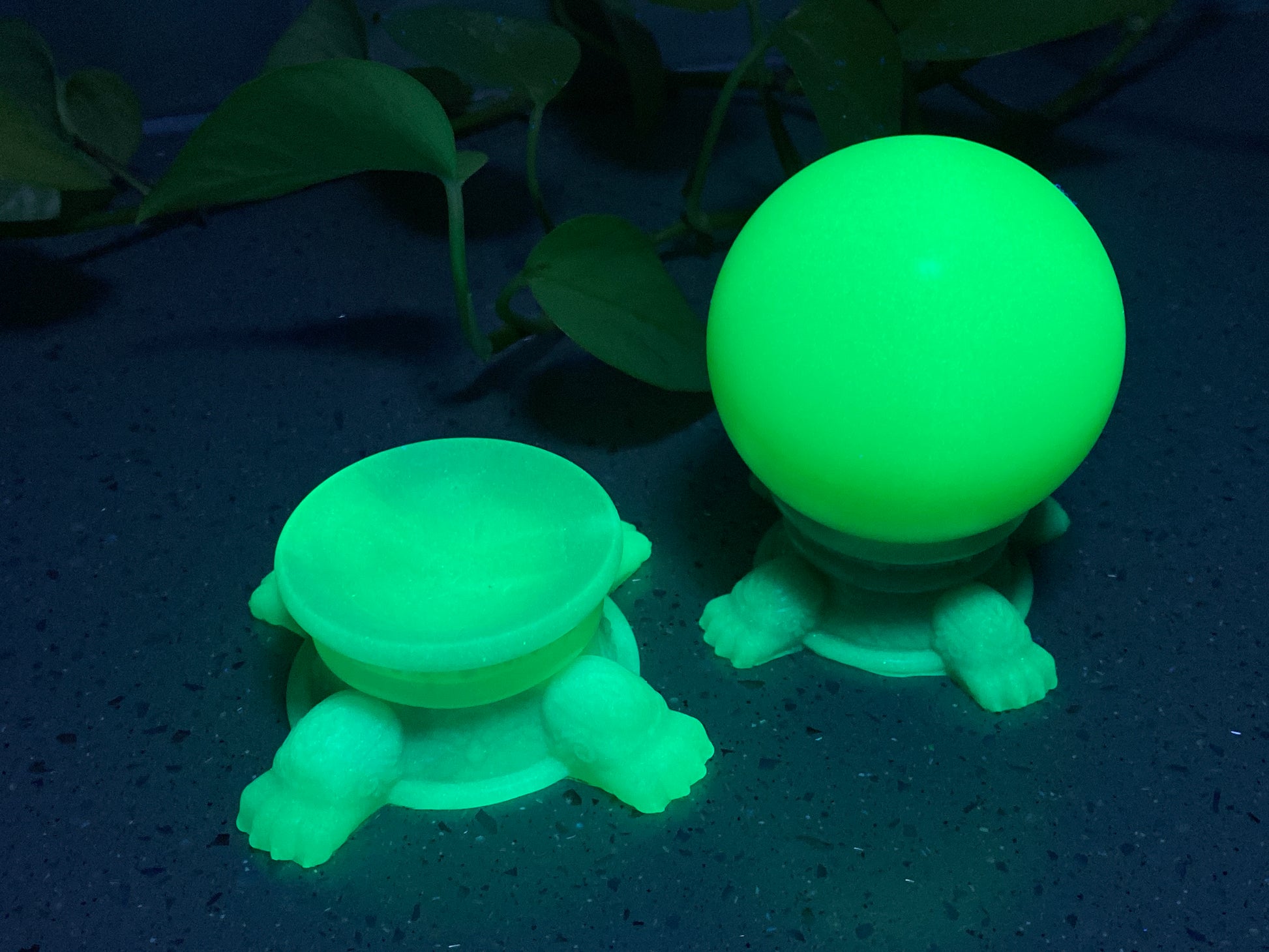 a green plastic turtle next to a green plastic ball