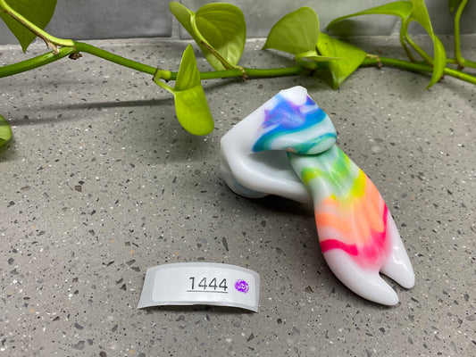 a tie - dyed object sitting on the ground next to a plant