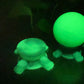 a glowing green toy next to a glowing green ball