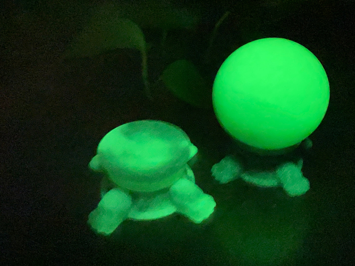 a glowing green toy next to a glowing green ball