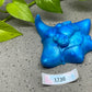 a blue statue of a bull head next to a plant