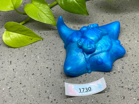 a blue statue of a bull head next to a plant